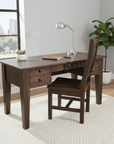 Wooden desk with chair in a room with large windows and plants