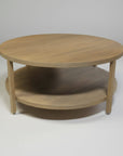 Round wooden coffee table with a shelf on a white background