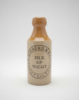 Vintage stoneware bottle with 'Gould, Hibberd & Randall' branding on a dark surface.