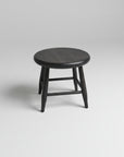 Round wooden stool with dark finish on a white background