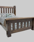 A rustic dark brown wooden bed frame with a slatted headboard and footboard, shown with patterned bedding and pillows on a white background.