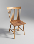 A wooden Modern Shaker Chair with a scooped out seat and a slatted backrest, displayed against a plain background.