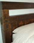 Wooden headboard with white bedding against a plain wall