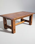 A rectangular Timber Trestle Table with a solid wood construction and bolt accents on the edges.