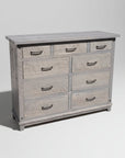 A rustic Adirondack style dresser with nine drawers, featuring bolt accents and a millsawn wood texture.