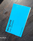 A bright blue Argus mini palmatic instruction booklet lies diagonally on a dark wooden surface. The text 'argus mini palmatic' is printed on the cover in black, and a small text watermark 'Galaxy S20 5G' is visible in the bottom-left corner.