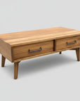 A mid century modern style coffee table made of solid wood, featuring two drawers with metal handles.