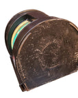 A vintage, heavily worn brown plastic half-cylinder container or spool, shown at an angle on a plain white background.