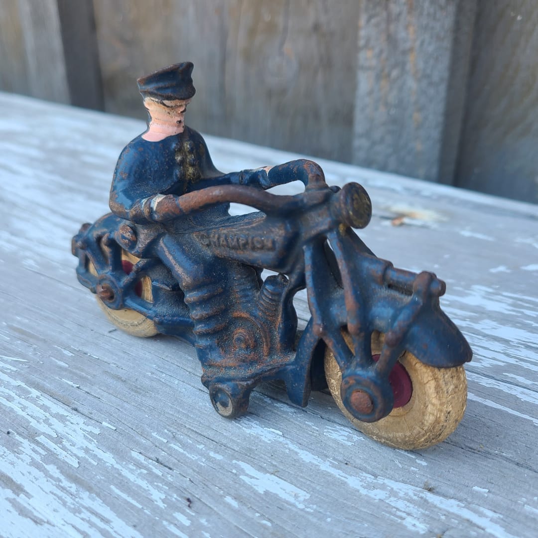 Vintage toy motorcycle with a rider on a wooden surface
