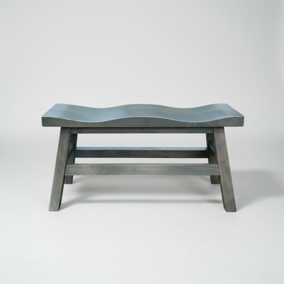 A Dakota saddle bench with a unique scooped top design, made of solid wood with a dark finish.