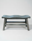 A Dakota saddle bench with a unique scooped top design, made of solid wood with a dark finish.