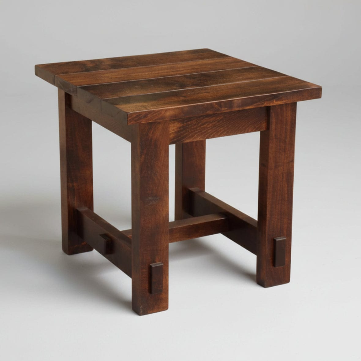 Wooden side table with a dark brown finish on a white background