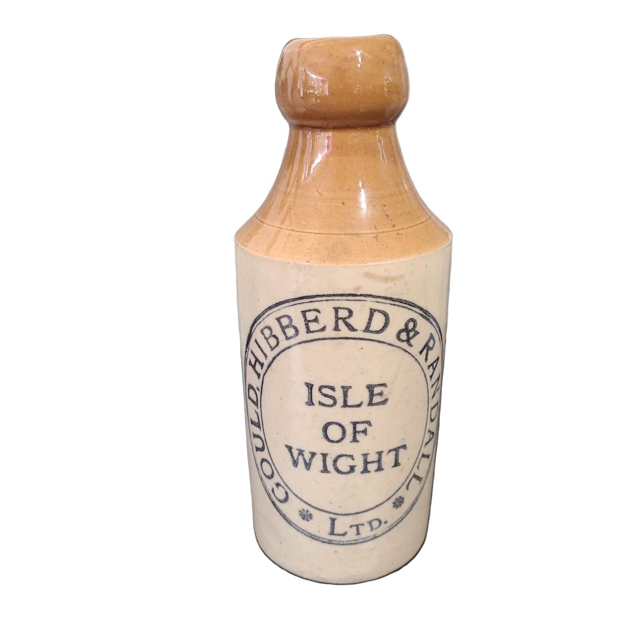 Vintage stoneware bottle with 'Gould, Hibberd & Randall' branding on a dark surface.