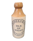 Vintage stoneware bottle with 'Gould, Hibberd & Randall' branding on a dark surface.