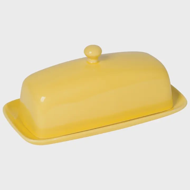 A yellow ceramic butter dish with a matching lid and small knob, shown on a light gray background.