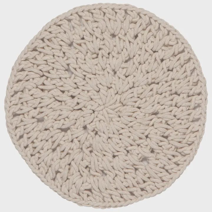 A round, hand-made knotted trivet in a light oatmeal beige color, shown from a top-down view against a neutral light gray background.