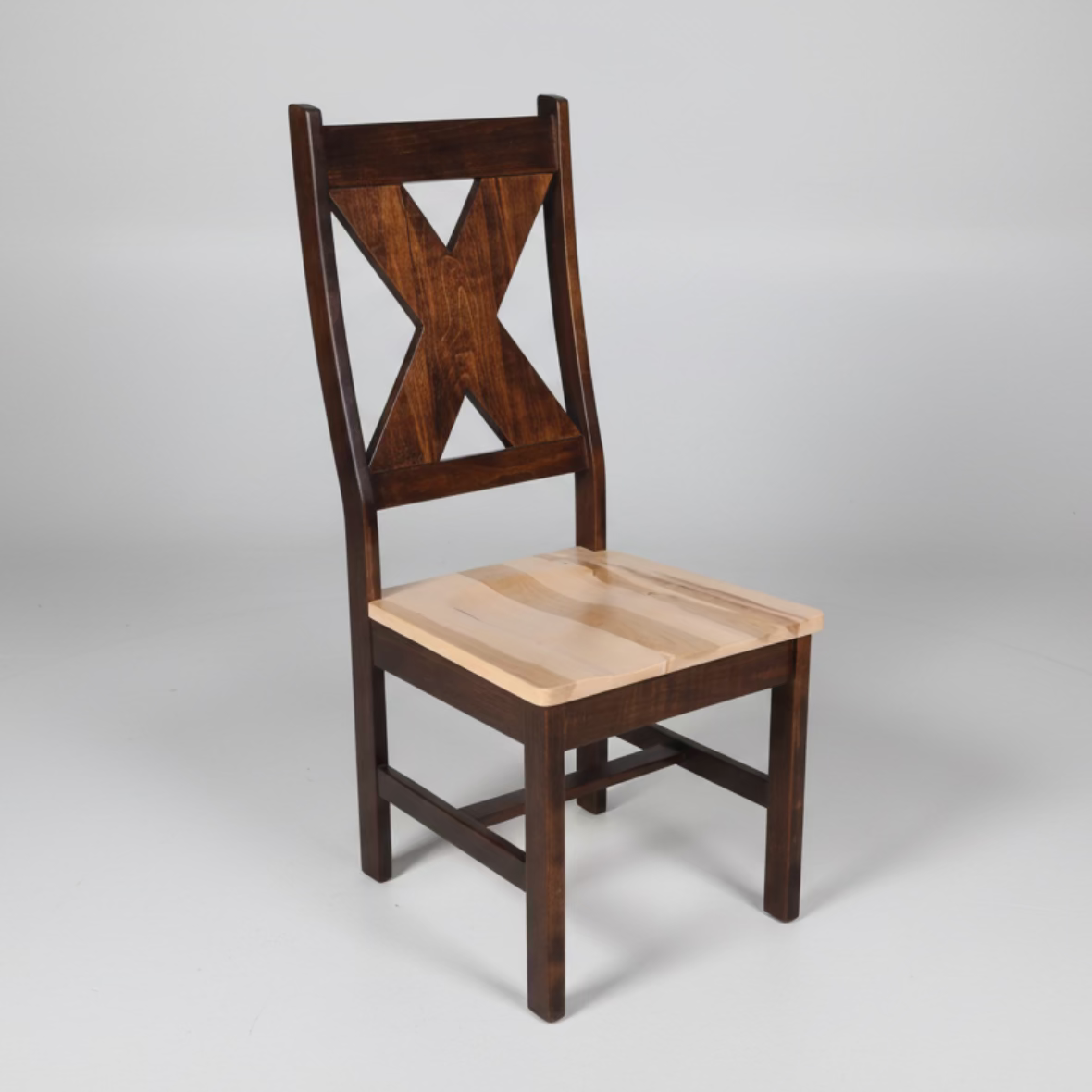 A rustic Sawbuck X Back Chair made of solid wood, with a scooped seat and a distinctive X-shaped backrest.
