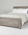 A rustic Sequoia Bed with a solid wood construction, displayed with a mattress and pillows on it.