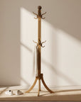 Wooden coat stand with multiple hooks on a light gray background
