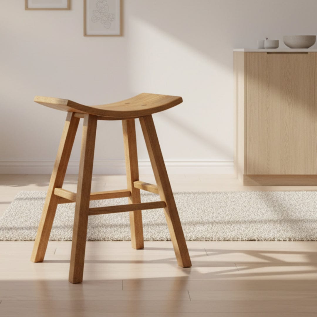 Wooden stool with curved seat against a wooden fence background