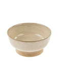 A beige stoneware pedestal bowl with a creamy reactive glaze on the interior and an unglazed pedestal bottom.