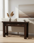 Dark wooden console table with two drawers on a light gray background
