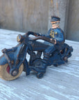 Vintage toy figure of a police officer on a motorcycle on a wooden surface