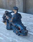 Vintage blue cast iron toy figure of a person on a motorcycle
