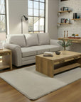 Living room with a gray sofa, wooden coffee table, and shelves.
