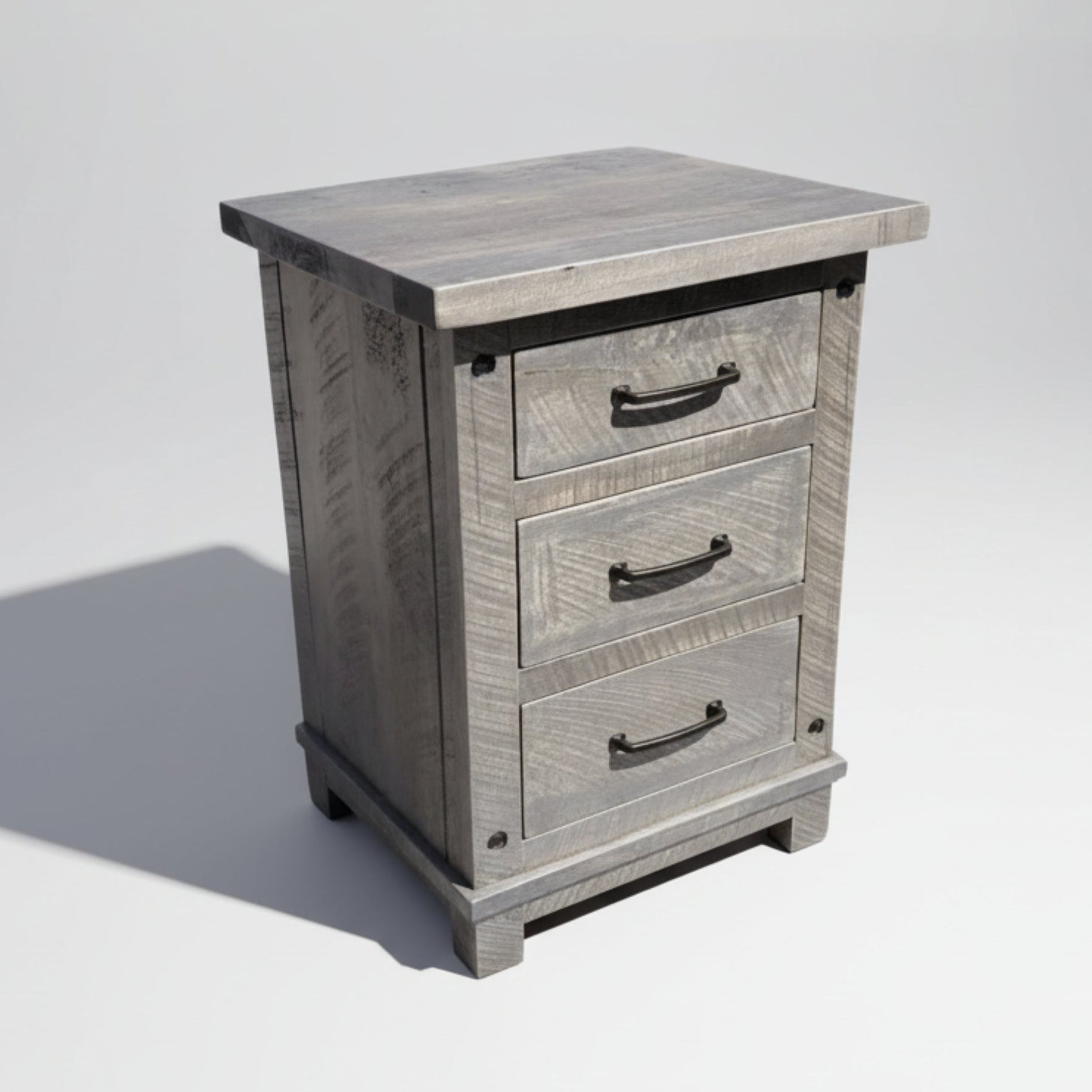 A rustic Adirondack style nightstand with three drawers, made from solid wood with visible grain and bolt accents, finished in a gray color.