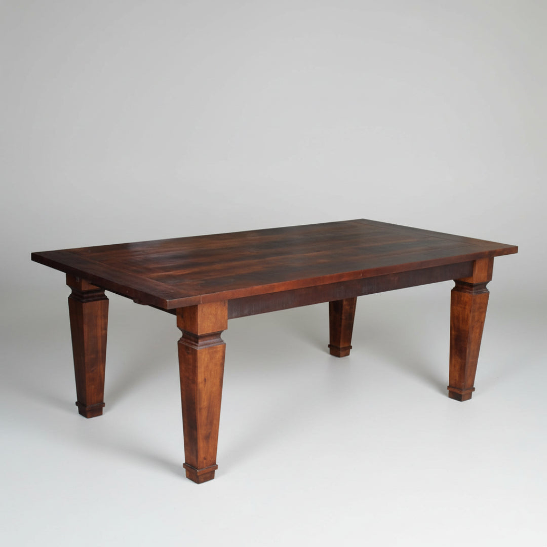 A rectangular, brown, solid wood dining table with visible wood grain and grooved leg design.