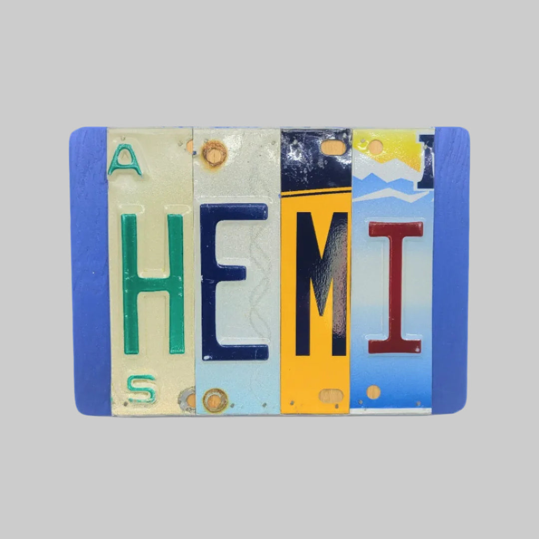 A custom license plate sign made from repurposed license plates, mounted on a wooden background with a variety of colorful text and graphics.