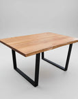 A rectangular live edge table with a smooth wood texture and black metal legs.