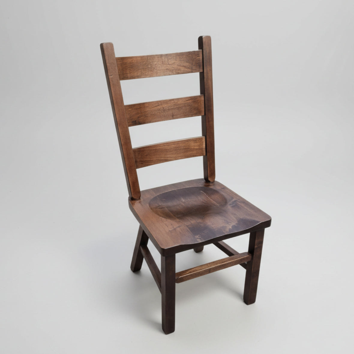 A rustic ladder chair made of solid wood with a seat scoop and a backrest, featuring a natural wood finish.