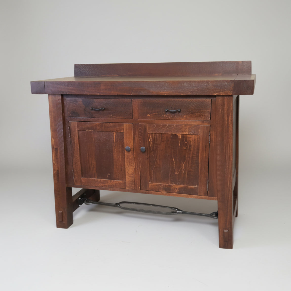 A wooden sideboard with a unique metal turnbuckle design, featuring two drawers and two doors, finished in a rustic style.